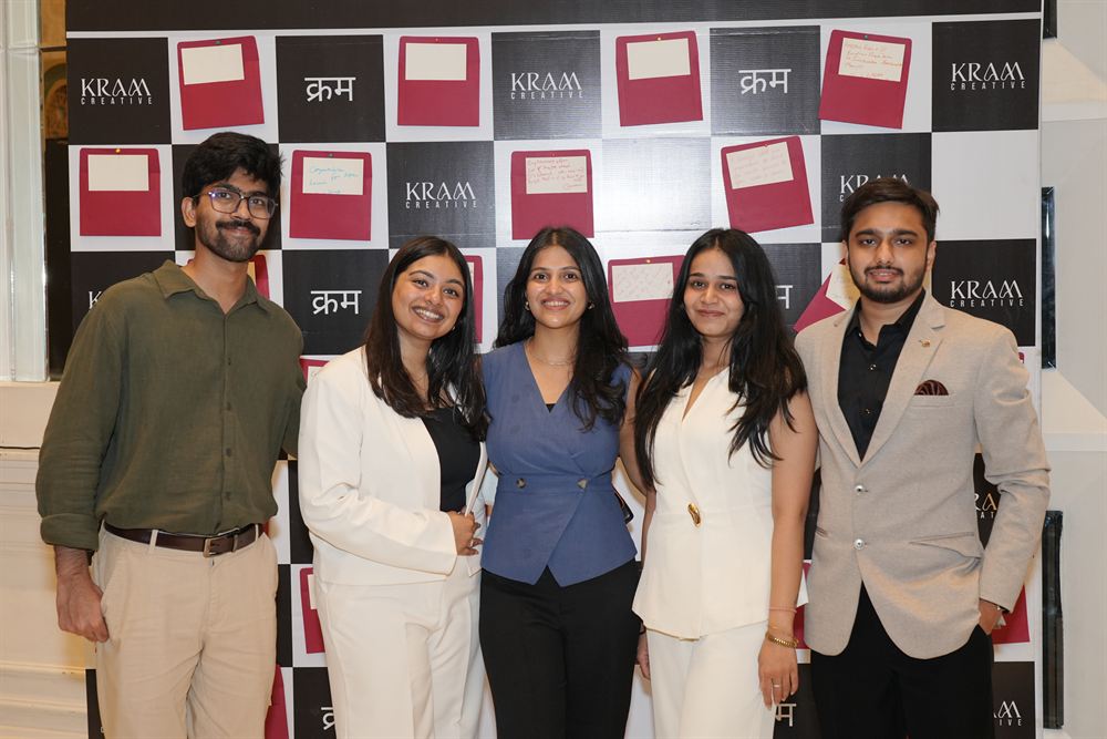 Five of the KRAM Creative team at the branded launch backdrop